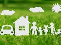 Paper cut of family with house and car on green grass