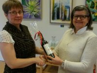 Powerjobsøger Linda Hudson modtager ros og rødvin for sin store indsats som næstformand hos Poerjobsøgerne i Sorø fra medarbejder i sekretariatet Poerjobsøgerne Ann G. Pedersen.