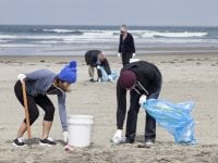 group of volunteers help clean up a public beach